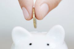 Saving, Hand Putting Golden Coin In Piggy Bank Stock Photography