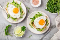 Savory waffles with avocado, arugula and fried egg for breakfast royalty free stock photos Savory waffles with avocado, arugula and fried egg for breakfast royalty free stock photos