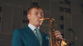 Saxophonist στην μπλε κομψή τζαζ παιχνιδιού κοστουμιών στο χρυσό saxophone στο στάδιο μουσική απόθεμα βίντεο Saxophonist στην μπλε κομψή τζαζ παιχνιδιού κοστουμιών στο χρυσό saxophone στο στάδιο μουσική απόθεμα βίντεο