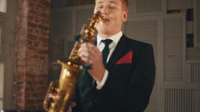 Saxophonist στο παιχνίδι σακακιών γευμάτων στο χρυσό saxophone στο στάδιο Καλλιτέχνης της Jazz φιλμ μικρού μήκους Saxophonist στο παιχνίδι σακακιών γευμάτων στο χρυσό saxophone στο στάδιο Καλλιτέχνης της Jazz φιλμ μικρού μήκους