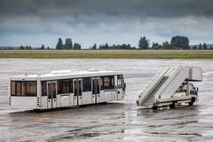 Scale di imbarco del bus e del passeggero di navetta al grembiule dell'aeroporto Fotografia Stock Scale di imbarco del bus e del passeggero di navetta al grembiule dell'aeroporto Fotografia Stock