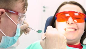Scared patient with a doctor trying to examine her in a dentist office, dental care concept. Media. A young girl in stock footage Scared patient with a doctor trying to examine her in a dentist office, dental care concept. Media. A young girl in stock footage