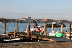 Scarico delle merci dalle barche sul pilastro di Venezia nel primo mattino immagine stock libera da diritti Scarico delle merci dalle barche sul pilastro di Venezia nel primo mattino immagine stock libera da diritti