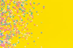 Scattering multicolored confectionery topping dressing on yellow paper. Festive background. Copy space, Top view royalty free stock photos Scattering multicolored confectionery topping dressing on yellow paper. Festive background. Copy space, Top view royalty free stock photos