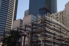 New construction site with workers in cherry pickers surrounded by older buildings stock photo New construction site with workers in cherry pickers surrounded by older buildings stock photo