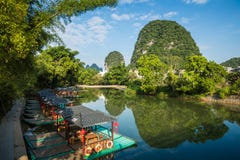 Scenic view of small tourist bamboo rafts sailing along the Yulo Stock Photos Scenic view of small tourist bamboo rafts sailing along the Yulo Stock Photos