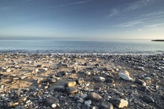 Sceniczna Kamienista plaża w ranku świetle zdjęcia stock Sceniczna Kamienista plaża w ranku świetle zdjęcia stock