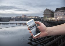 Sceniczny widok most i budynki stara grodzka ręka z smartphone na ekranie dziejowy centrum Praga, Charles, z czego zdjęcia royalty free Sceniczny widok most i budynki stara grodzka ręka z smartphone na ekranie dziejowy centrum Praga, Charles, z czego zdjęcia royalty free