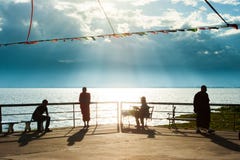 Sch?ne Sommerzeit, ruhiges szenisches des Seeufers an der D?mmerung, buddhistische M?nche und Leute, die im Sonnenunterganglicht, lizenzfreie stockfotos Sch?ne Sommerzeit, ruhiges szenisches des Seeufers an der D?mmerung, buddhistische M?nche und Leute, die im Sonnenunterganglicht, lizenzfreie stockfotos
