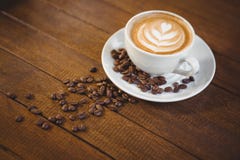 Schale Cappuccino mit Kaffeekunst und Kaffeebohnen Lizenzfreies Stockbild Schale Cappuccino mit Kaffeekunst und Kaffeebohnen Lizenzfreies Stockbild