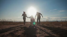 Schattenbild der glücklichen Familie das, die mit dem Ball auf Wiese zur Sonnenuntergangzeit spielt Konzept der freundlichen Fami stock video footage Schattenbild der glücklichen Familie das, die mit dem Ball auf Wiese zur Sonnenuntergangzeit spielt Konzept der freundlichen Fami stock video footage