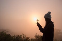 Schattenbild der jungen Frau betend mit einem Kreuz bei Sonnenaufgang, Christian Religions-Konzepthintergrund lizenzfreie stockfotografie Schattenbild der jungen Frau betend mit einem Kreuz bei Sonnenaufgang, Christian Religions-Konzepthintergrund lizenzfreie stockfotografie