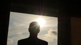 Schattenbild der Mannöffnungsvorhangzeitlupe Von der Dunkelheit in Licht Schattenbild der Mannöffnungsvorhangzeitlupe Von der Dunkelheit in Licht