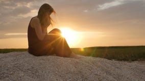 Schattenbild einer jungen Frau auf dem Sand bei Sonnenuntergang, Mädchen, das zum Gott auf Horizont, das Konzept von Ferien, Reli stock footage Schattenbild einer jungen Frau auf dem Sand bei Sonnenuntergang, Mädchen, das zum Gott auf Horizont, das Konzept von Ferien, Reli stock footage
