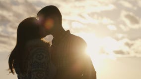 Schattenbild eines jungen Paares in der Liebe auf dem Hintergrund des Himmels und der Sonne, einander betrachtend stock video footage Schattenbild eines jungen Paares in der Liebe auf dem Hintergrund des Himmels und der Sonne, einander betrachtend stock video footage