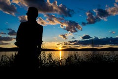 Schattenbild eines Mannes vor einem drastischen und schönen Sonnenuntergang, durch Hudson River, im Hinterland New York, NY stockfotografie Schattenbild eines Mannes vor einem drastischen und schönen Sonnenuntergang, durch Hudson River, im Hinterland New York, NY stockfotografie