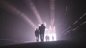 Schattenbild vieler Bauarbeiter, die heraus von einem großen Tunnel gehen stock video footage Schattenbild vieler Bauarbeiter, die heraus von einem großen Tunnel gehen stock video footage