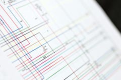 Schema elettrico dei collegamenti delle automobili variopinte sullo strato di carta immagine stock libera da diritti Schema elettrico dei collegamenti delle automobili variopinte sullo strato di carta immagine stock libera da diritti