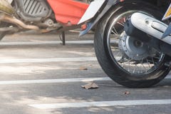 Schließen Sie herauf den Reifen des Motorrades geparkt auf konkretem Boden am Parkplatzlos an im Freien Lizenzfreies Stockbild Schließen Sie herauf den Reifen des Motorrades geparkt auf konkretem Boden am Parkplatzlos an im Freien Lizenzfreies Stockbild