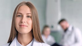 Schließen Sie herauf medizinischen weiblichen Spezialisten des Porträts den recht, der am typischen Arbeitsumfeld lächelt und auf stock video Schließen Sie herauf medizinischen weiblichen Spezialisten des Porträts den recht, der am typischen Arbeitsumfeld lächelt und auf stock video