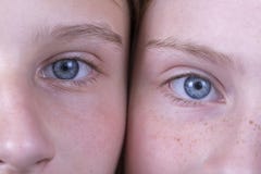 Schließen Sie herauf zwei Augen des jungen Mädchens, sie betrachten die Kamera, Paarporträtkinder, Makro stockbild Schließen Sie herauf zwei Augen des jungen Mädchens, sie betrachten die Kamera, Paarporträtkinder, Makro stockbild