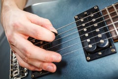 Schließen Sie oben vom Mann, der auf E-Gitarre spielt lizenzfreie stockbilder Schließen Sie oben vom Mann, der auf E-Gitarre spielt lizenzfreie stockbilder