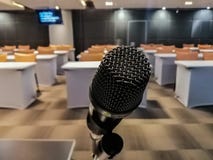 Schließen Sie oben vom schwarzen Mikrofon sitzt vor dem Konferenzzimmer stockbild Schließen Sie oben vom schwarzen Mikrofon sitzt vor dem Konferenzzimmer stockbild