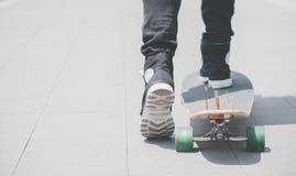 Schließen Sie oben vom skater& x27; s-Beine auf dem longboard Reiten an der Straße herein draußen stockfotos Schließen Sie oben vom skater& x27; s-Beine auf dem longboard Reiten an der Straße herein draußen stockfotos