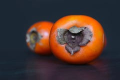 Schließen Sie oben von den reifen orange Diospyroskakipflaumenbaum Persimonefrüchten auf dunklem Hintergrund lizenzfreie stockfotos Schließen Sie oben von den reifen orange Diospyroskakipflaumenbaum Persimonefrüchten auf dunklem Hintergrund lizenzfreie stockfotos