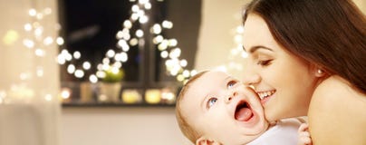 Schließen Sie oben von der Mutter mit Baby über Weihnachtslichtern lizenzfreie stockbilder Schließen Sie oben von der Mutter mit Baby über Weihnachtslichtern lizenzfreie stockbilder