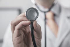 Schließen Sie oben von männlichem Doktor, der ein Stethoskop hält lizenzfreie stockbilder Schließen Sie oben von männlichem Doktor, der ein Stethoskop hält lizenzfreie stockbilder
