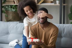 Schließend Augen der afrikanischen Kindertochter, die den Vati gibt Geschenkbox beglückwünschen stockfotos Schließend Augen der afrikanischen Kindertochter, die den Vati gibt Geschenkbox beglückwünschen stockfotos
