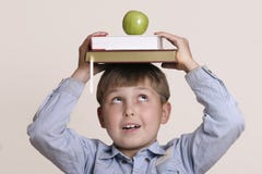 Scholastic. Schoolboy with books and green apple Scholastic. Schoolboy with books and green apple