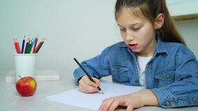 School girl in jeans wear drawing with colored pencil at home stock video footage School girl in jeans wear drawing with colored pencil at home stock video footage