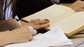 School student`s taking exam writing answer in classroom for education and literacy concept. Young female student writes royalty free stock photography School student`s taking exam writing answer in classroom for education and literacy concept. Young female student writes royalty free stock photography