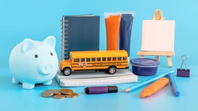 School supplies and piggy bank on blue.