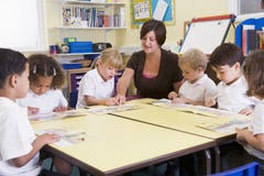 Schoolchildren and their teacher reading in primar