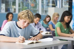 Schooljongen in middelbare schoolklasse royalty-vrije stock foto Schooljongen in middelbare schoolklasse royalty-vrije stock foto