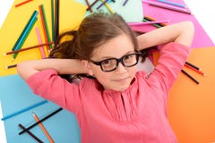 Schoolmeisje die op de vloer met kleurenpotloden liggen stock afbeeldingen Schoolmeisje die op de vloer met kleurenpotloden liggen stock afbeeldingen