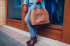 Schoonheid en manier Modieuze modieuze vrouw die laag en handschoenen dragen, die bruine zakhandtas houden royalty-vrije stock afbeelding Schoonheid en manier Modieuze modieuze vrouw die laag en handschoenen dragen, die bruine zakhandtas houden royalty-vrije stock afbeelding
