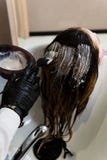 Schoonheid en mensenconcept - sluit omhoog van stilist met haarverf en borstel kleurend haar bij salon stock afbeelding Schoonheid en mensenconcept - sluit omhoog van stilist met haarverf en borstel kleurend haar bij salon stock afbeelding