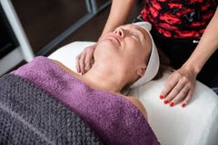 Schoonheidsspecialist Standing By Customer die Behandeling in Salon ondergaan stock fotografie Schoonheidsspecialist Standing By Customer die Behandeling in Salon ondergaan stock fotografie
