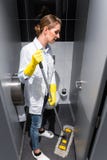 Schoonmaakster of portier die de vloer in toilet dweilen royalty-vrije stock foto Schoonmaakster of portier die de vloer in toilet dweilen royalty-vrije stock foto