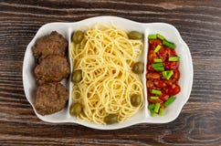 Schotel met spaghetti, kotelet, bonen, groene ui en olijven op lijst Hoogste mening royalty-vrije stock afbeeldingen Schotel met spaghetti, kotelet, bonen, groene ui en olijven op lijst Hoogste mening royalty-vrije stock afbeeldingen