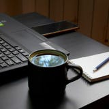 Schreibtisch mit Laptop, intelligentem Telefon, Notizbüchern, Stiften, Brillen und einer Tasse Tee Seitenwinkelsicht lizenzfreie stockfotos Schreibtisch mit Laptop, intelligentem Telefon, Notizbüchern, Stiften, Brillen und einer Tasse Tee Seitenwinkelsicht lizenzfreie stockfotos