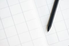 Schwarzer Stift gesetzt auf einen Notizblock mit Blockschachbrettmuster stockfotos Schwarzer Stift gesetzt auf einen Notizblock mit Blockschachbrettmuster stockfotos