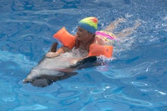 Schwimmen des kleinen Mädchens auf Delphin lizenzfreie stockbilder Schwimmen des kleinen Mädchens auf Delphin lizenzfreie stockbilder