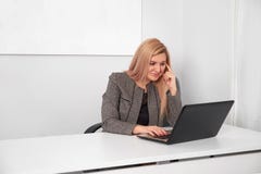 Schöne Geschäftsfrau arbeitet hinter Laptop im Büro lizenzfreie stockbilder Schöne Geschäftsfrau arbeitet hinter Laptop im Büro lizenzfreie stockbilder