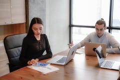 Schöne Geschäftsfrau sitzen auf dem Stuhl, der mit Tablette und Laptop arbeitet stockbilder Schöne Geschäftsfrau sitzen auf dem Stuhl, der mit Tablette und Laptop arbeitet stockbilder