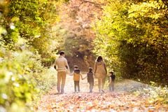 Schöne junge Familie auf einem Weg im Herbstwald lizenzfreies stockfoto Schöne junge Familie auf einem Weg im Herbstwald lizenzfreies stockfoto